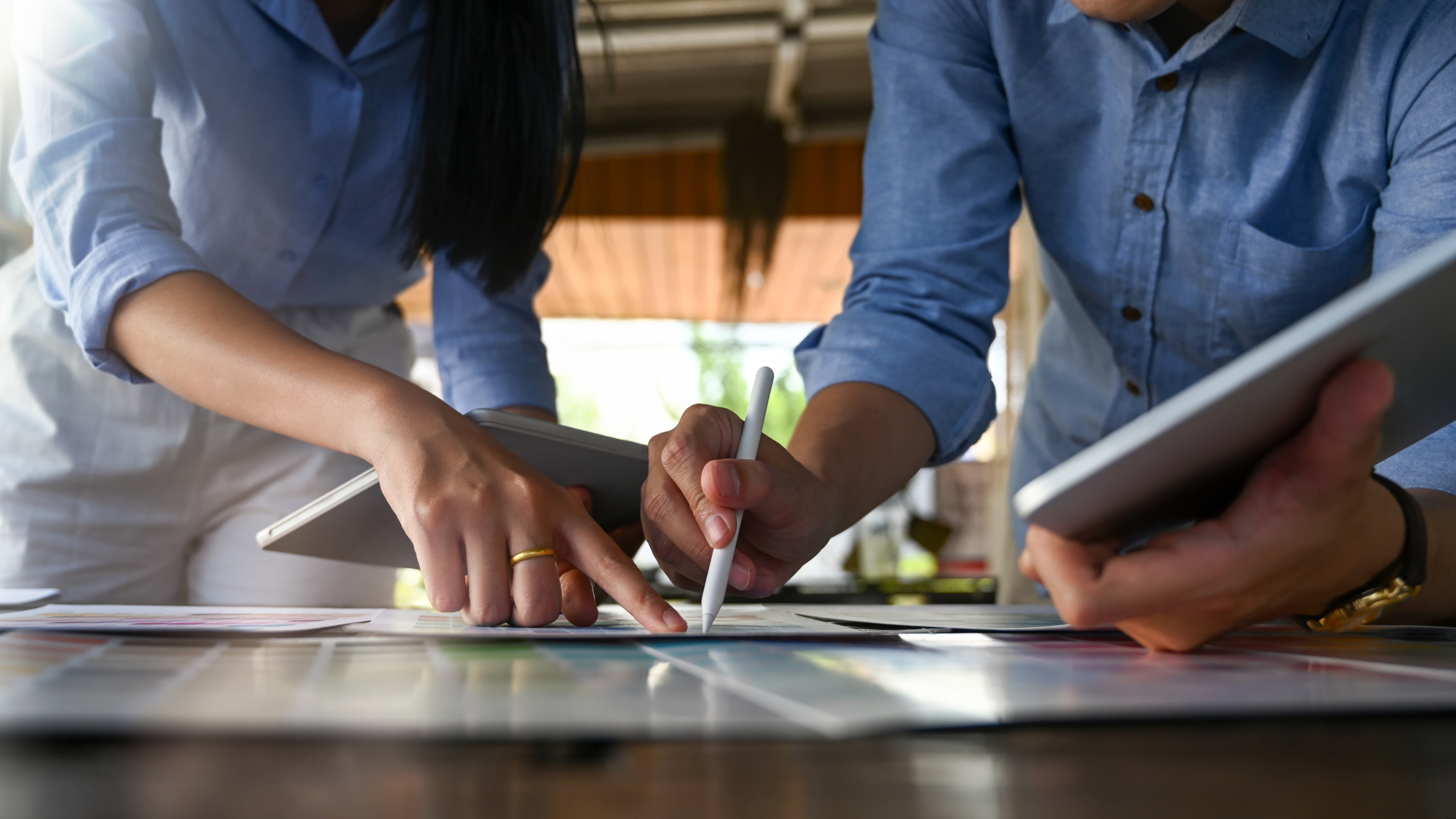 Cropped image of young graphic designer team holding/using a sty